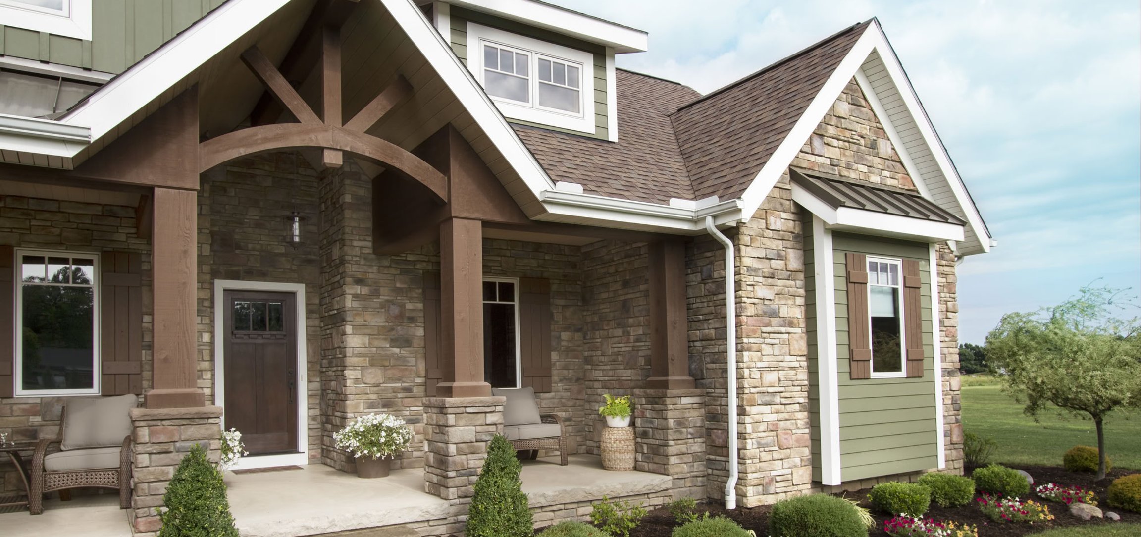 Stone and wood craftsman home with covered front porch.
