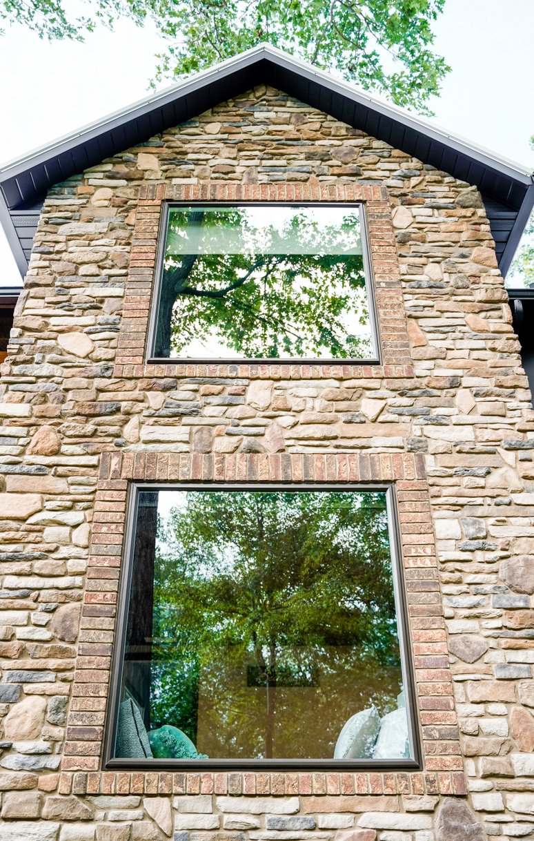 Navy blue front door with decorative glass and sidelights.