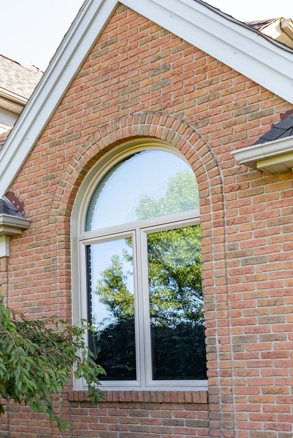 Gray stone exterior home with black shuttered windows.